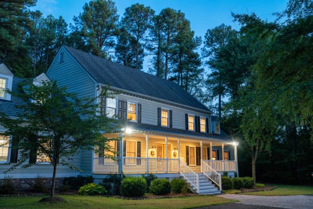 Home illuminated colonial style house at dusk